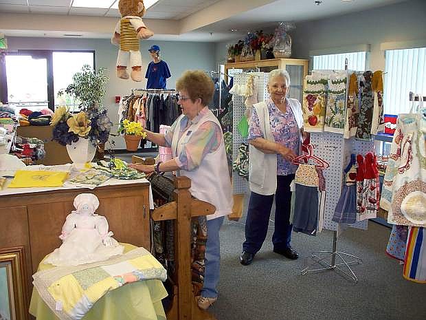LaVonne Birdwell, manager,  left, and Laura Hersh, volunteer and former manager, arrange items in the gift shop.