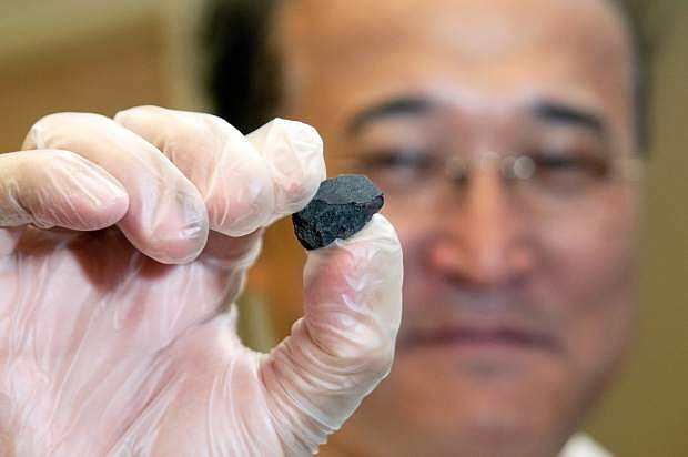 UC Davis geology professor Qing-zhu Yin holds a fragment of the Sutter&#039;s Mill meteorite donated by an alum in spring 2012. UC Davis is one of five institutions that have since acquired the main mass of the Sutter&#039;s Mill meteorite.