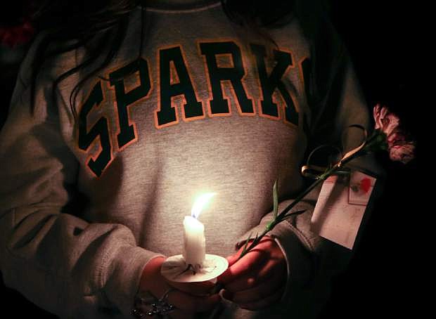Hundreds of students and residents attend a candlelight vigil at Sparks Middle School in Sparks, Nev., on Wednesday, Oct. 23, 2013, in honor of slain teacher Michael Landsberry and two 12-year-old students who were injured after a fellow student open fire at the school on Monday, before turning the gun on himself.  (AP Photo/Cathleen Allison)