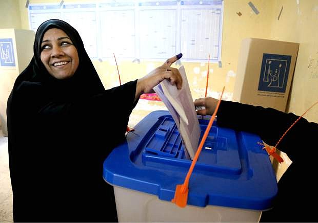 An Iraqi woman casts her vote inside a polling station for parliamentary elections in Baghdad, Iraq, Wednesday, April 30, 2014. Iraq is holding its third parliamentary elections since the U.S.-led invasion that toppled dictator Saddam Hussein.  More than 22 million voters are eligible to cast their ballots to choose 328 lawmakers out of more than 9,000 candidates. (AP Photo/Karim Kadim)