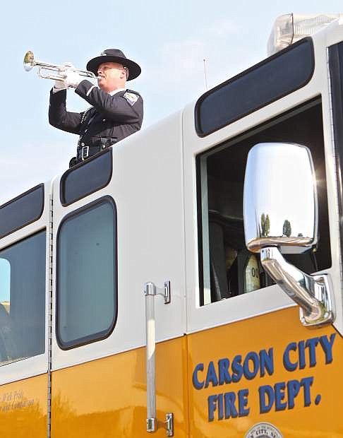 Trooper Christopher Johnson plays Taps atop a Carson City firetruck Friday morning during the 9/11 Memorial service in Mills Park.