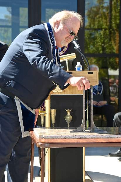 Grand Lodge member Mark A. Marsh ceremoniously checks the level of the cornerstone at the Nevada State Museum Saturday during a re-dedication ceremony.