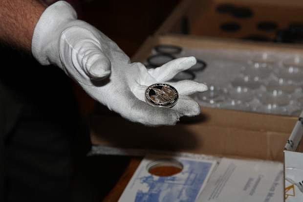 Ken Hopple displays a freshly pressed coin on Friday at the state museum in Carson City.