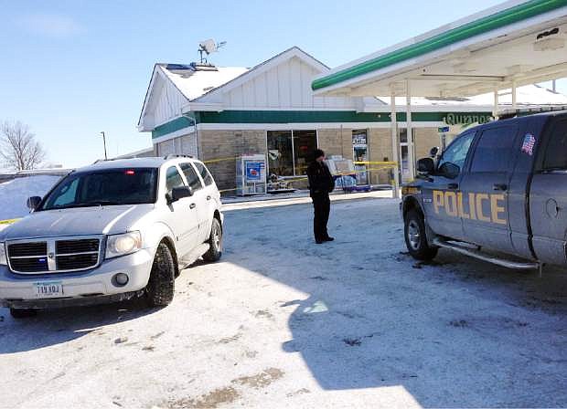 Authorities gather at a gas station in West Branch, Iowa, where a missing newborn was found alive Friday, Feb. 7, 2014. Police said they found Kayden Powell, who&#039;s nearly a week old, after they heard the newborn crying and found the child swaddled in blankets inside a tote bag outside the gas station. Police said the baby was in excellent health. (AP Photo/Ryan J. Foley)