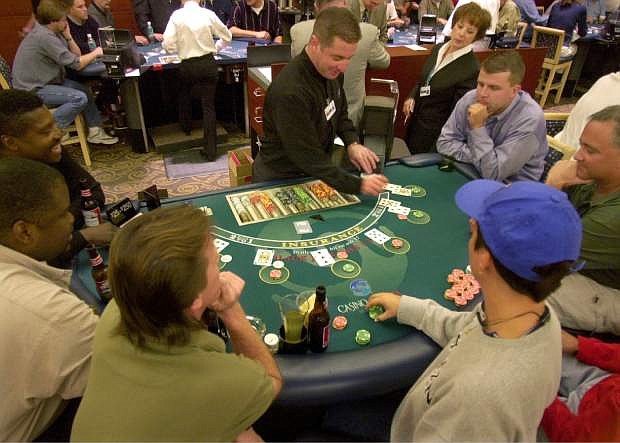 FILE - This Feb. 5, 2003 file photo shows a blackjack dealer working at Casino Arizona on the Salt River-Pima Maricopa Indian Community, Ariz. The credit rating agency Moody&#039;s Investors Services says established gambling states like Nevada and New Jersey are hurting as more states enter the market. The agency issued a report saying that casino tax revenues are shifting away from Las Vegas and Atlantic City, and migrating to new markets in places like Illinois, Arizona and Ohio. (AP Photo/Paul Connors, File)