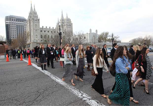 People walk pass the Salt Lake Temple on the way to the Conference Center during opening session of the two-day Mormon church conference Saturday, April 5, 2014, in Salt Lake City. More than 100,000 Latter-day Saints are expected in Salt Lake City this weekend for the church&#039;s biannual general conference. Leaders of The Church of Jesus Christ of Latter-day Saints give carefully crafted speeches aimed at providing members with guidance and inspiration in five sessions that span Saturday and Sunday.   (AP Photo/Rick Bowmer)