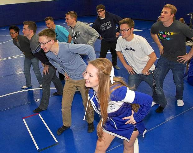 CHS cheerleader Kelly Canfield leads Mr. Carson High contestants through their opening dance routine Friday in the wrestling room.