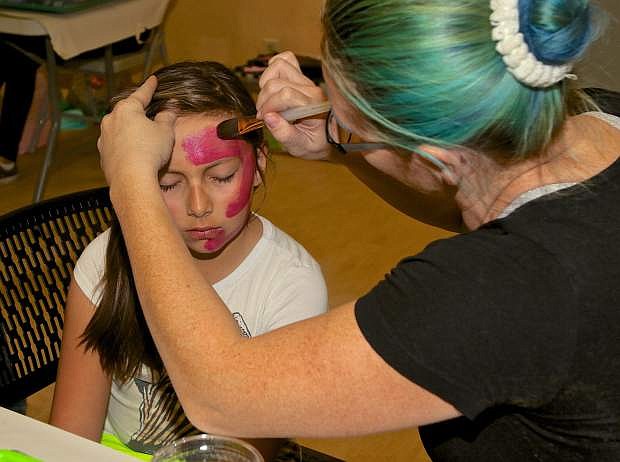 9-year-old Rhianna Redwine has her face painted by Britt Gianotti Saturday morning at the Nevada State Museum.