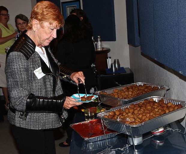 Regina Groman serves herself some meatballs Wednesday evening at the Carson City Chamber mixer at the Nevada Appeal offices.