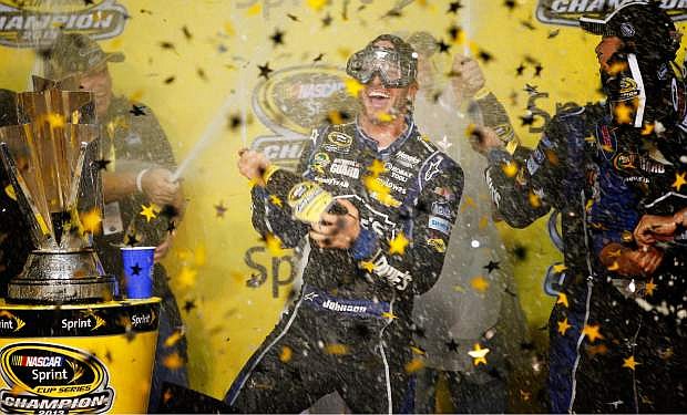 Jimmie Johnson celebrates after winning his sixth NASCAR Sprint Cup Series auto race title in eight years in Homestead, Fla., Sunday, Nov. 17, 2013. (AP Photo/Terry Renna)