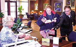 Carson City residents Megan Burdette and Charles Olinger pick up free American flags from Kathie James at Heritage Bank.  Bank officials said they&#039;d handed out about 150 at the Carson City branch on Wednesday afternoon.