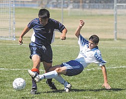 Carlos Hernandez takes the ball away from a Reno High School defender late in the first half. Carson came from behind to win 3-2. Photo by Brian Corley