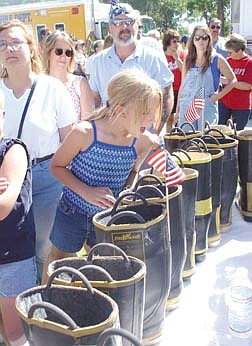 Katy Runde, 11, looks in a money-filled boot at a barbeque organized by the Carson City Fire Department. The barbeque was held in an effort to try and raise money for New York City firefighters. Photo by Brian Corley