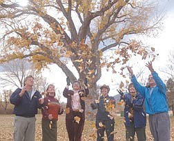 Mike Hoffman, left, Susan Hoffman, Isabel Espinoza, Eileen Cohen, Vivian Kuhn and Jon Nowlin throw leaves into the air that have fallen across Fuji Park. The group is hoping to save the fairgrounds from being developed into commercial property. Photo by Brian Corley