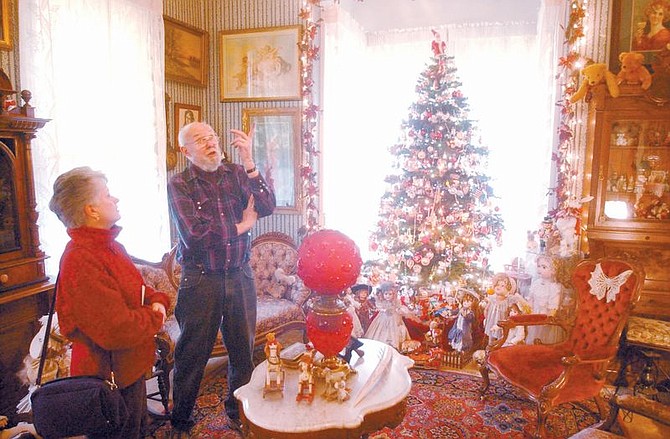 Peggy Trelford listens to Bud Klette as he talks about his home during the Victorian Christmas Home Tour. He moved into The Elliot-Chartz House in 1982 and has since remodelled most of his home that was built in 1876. Photo by Brian Corley