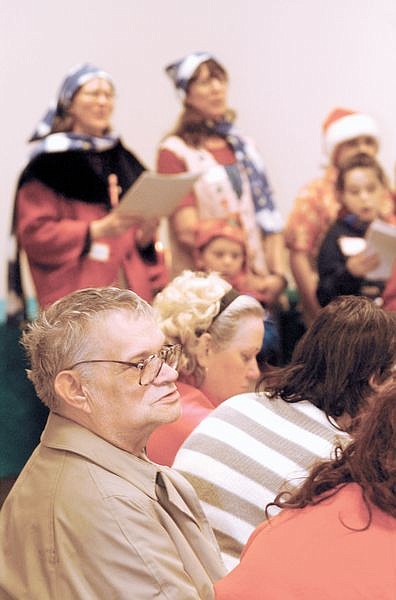 Gerald Harris listens to Christmas carols by the Home Schoolers Choir at the Nevada State Library and Archives Tuesday Evening during a Christmas dinner for the National Alliance for the Mentally Ill. NAMI members received gifts from anonymous donors.  Photo by Rick Gunn