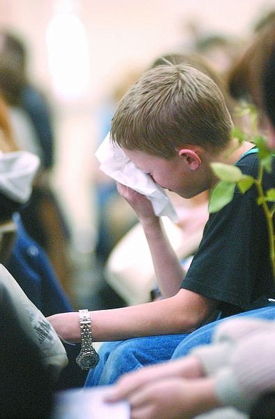 Walter Ball, 13, overcome with greif, wipes his eyes, during a memorial at Silver Stage Middle School for Karen Hatcher Friday after she was killed in a freak car accident along I-80 Monday morning. Photo by Brian Corley