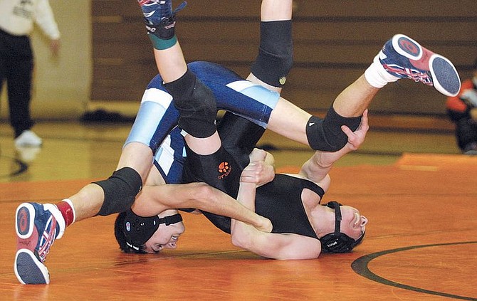 Eric Aguilera, left, of Carson High School, wrestles with Ryan Martinez of Douglas High School in the 103 match at DHS on Wednesday night.  Aguilera won the match.