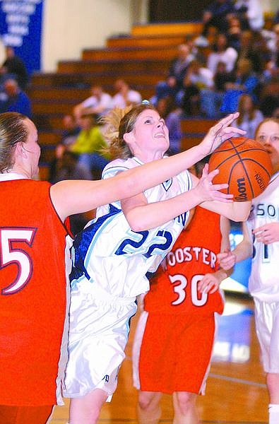 Kattie Kotter drives the lane in the opening moments of the second half as she is fouled by #35. Photo by Brian Corley