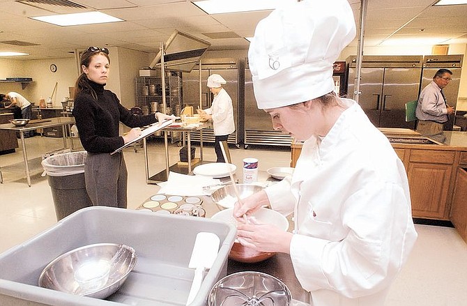 Left to to right, Laura Hartung of North Tahoe High School watches over CHS student Tamara Hall, 17, Wednesday afternoon at the Skills USA baking contest. Winners from the regional contest will advance to the state competition in April. photo by Rick Gunn