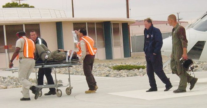 Medical personnel roll a crew member from a Navy HH-1 helicoptor crash near Lake Isabella, Calif., into Ridgecrest Regional Hospital in Ridgecrest, Calif., Thursday, March 28, 2002. The crash killed two crew members and injured four others. (AP Photo/Daily Independent of Ridgecrest, Darla A. Baker)