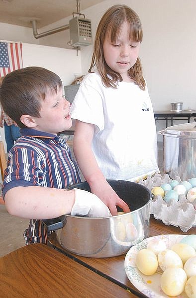 Billy Myer, 5, left, and Kyrstan Myer, 10, dip easter eggs into die at the Jack Valley Fire Station. Volunteers their colored 2,300 eggs for an easter egg hunt. Photo by Brian Corley