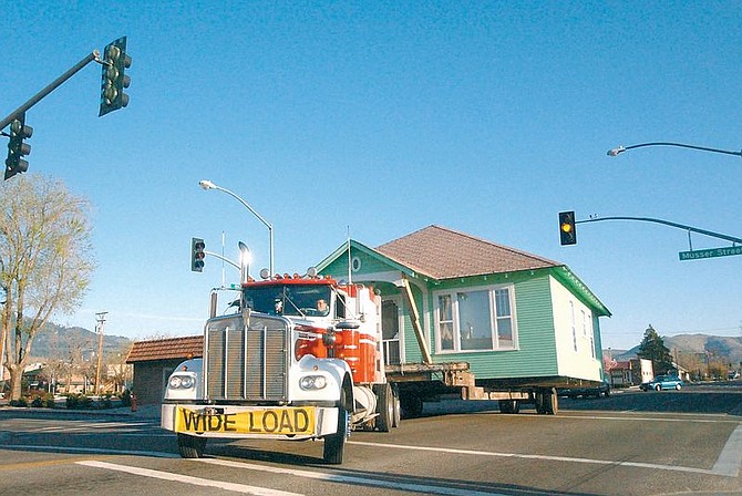 The house of Alan Marriage is moved between two low traffic signals along Stewart and Musser. The house was moved from Stewart and Musser to Betts and Lennox Sunday morning stopping traffic along Stewart and parts of Carson Street. Photo by Brian Corley