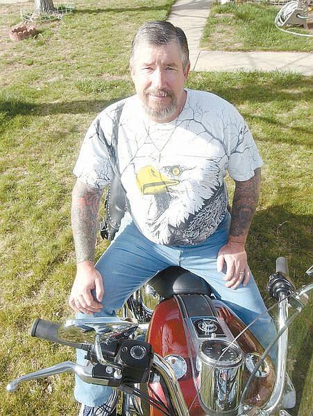 Gary James sits on his Harley-Davidson motorcycle in his front yard Friday. The ex-biker says he has seen it all and just wants to help teens avoid some of the mistakes he has made in the past. Photo by Brian Corley