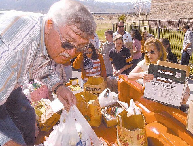 Photo by Brian CorleyWally Bennett, left, loads the back of a truck with food for Friends in Service Helping in the parking lot of St. Teresa of Avila Church in Carson City. Youthful church parishioners spent most of Sunday gathering food and items for their Sixth annual Scavenger Hunt.