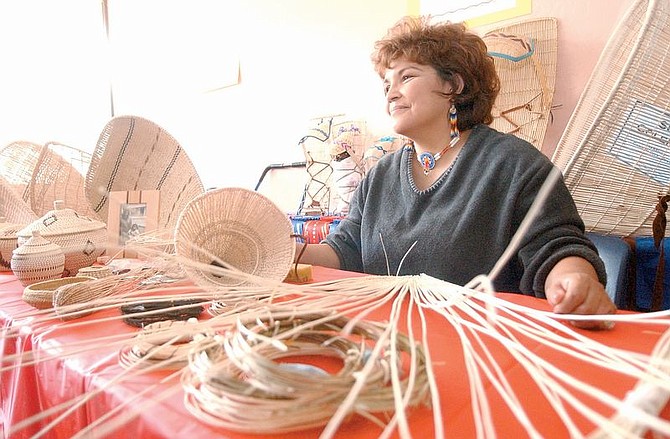 Sue Coleman sits at a display of Indian baskets that were made from woven willow stems. Coleman, a member of the Washoe Indian Tribe, say her trade is a dying trade among native Americans in the United States. Photo by Brian Corley
