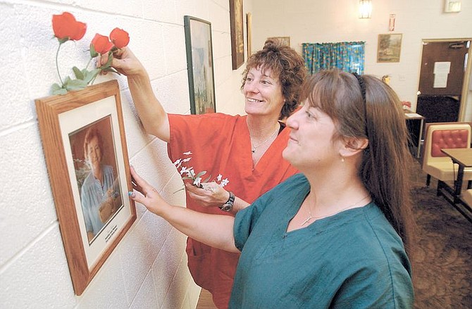 Right to Left Mary Jo Fischer and her sister Tish Koury, rehang a photo of their mother, June Koury, in the FISH family dining room she founded. FISH will celebrate Mother&#039;s Day on Sunday in June Koury&#039;s honor with a full dinner and roses for women. Photo by Rick Gunn
