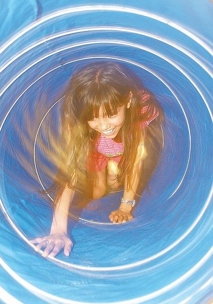 Claudia Rodriguez, 9, crawls through a plastic tube which is supposed to be the esophagus during the Body Walk at Empire Elementry School. Students at the school traveled through an imaginary human body and learned about different areas of the body and why they are necessary. Photo by Brian Corley