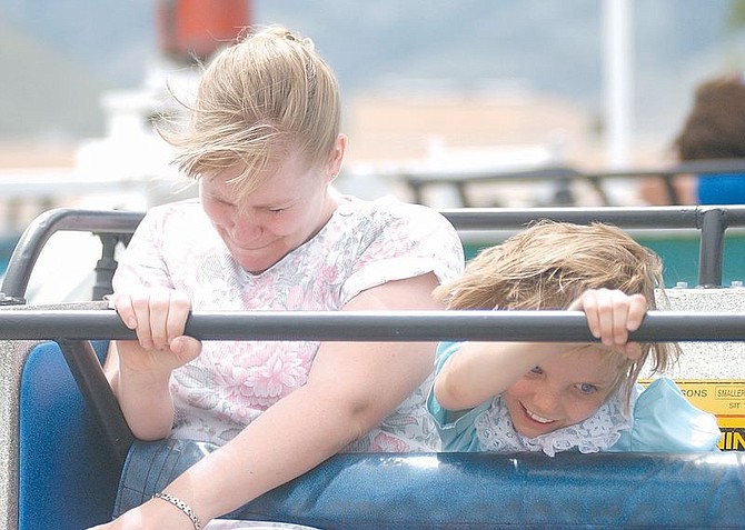 Jennifer Mastin, left, and her daughter, Rebecca Mastin, 7, go for a spin on the Super Sizzler at the Mother&#039;s Day Carnival at Mills Park. Mothers were given a hand stamp that allowed them on all the rides for free. Photo by Brian Corley