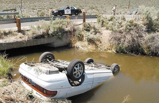 Photo by Rick GunnThree occupants of a vehicle traveling east on Carson River Road suffered minor injuries after failing to negotiate a curve and overturned into a canal near the Silver Saddle Ranch on Thursday afternoon.