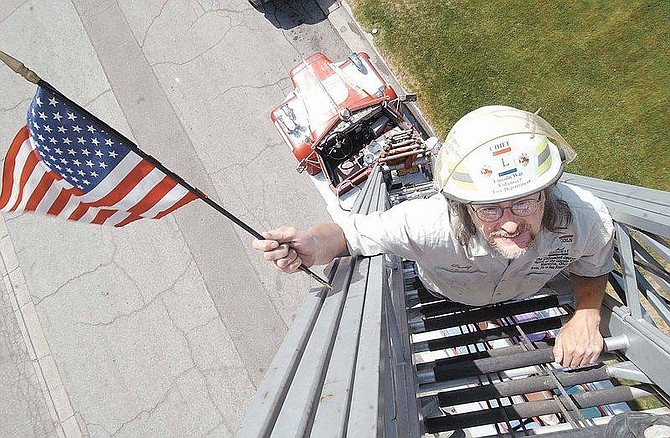 Photo by Rick GunnCraig Harmon, founder of the Lincoln Highway National Museum and Archives in Galion, Ohio, stands on the ladder of a 1964 Maxim firetruck.