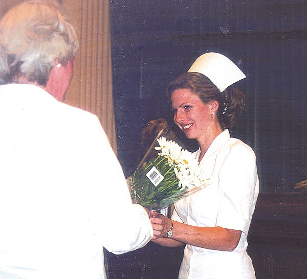 Erica Carlson receives a bouquet of daisys from her mother, who pinned her at the nurse&#039;s graduation on Tuesday night. Photo by Anne Hansen