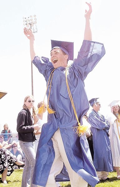 Julian Angres celebrates as he walks towards the podium to recieve his high school diploma at Carson High School Saturday. Photo by Brian Corley