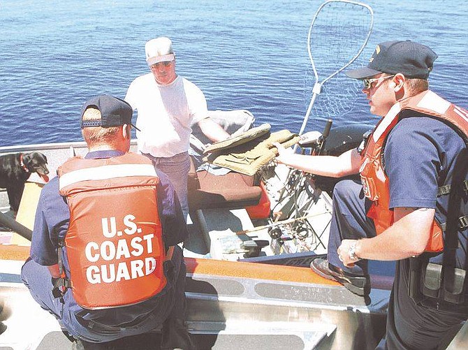 Photo by Jim GrantU.S. Coast Guard crew members Billy Whitted, right, and Daniel Maloney conduct a boat safety inspection near Cave Rock on Thursday.