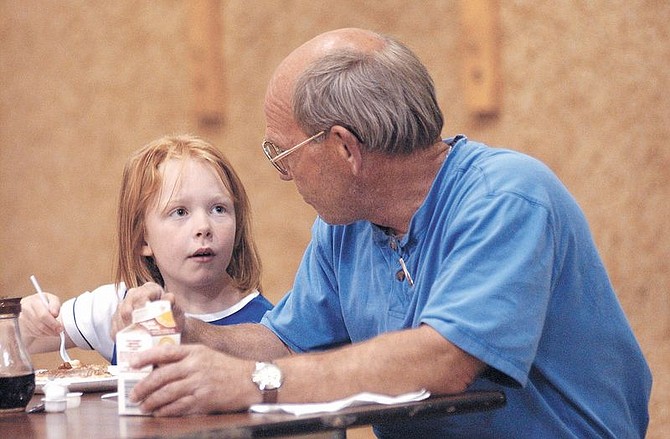 Darian Shaeldon, 8, left, and her father, Brian Sheldon, share a moment together at the Little League Father&#039;s Day Pancake Breakfast sunday at Seelinger Elementry School. Photo by Brian Corley