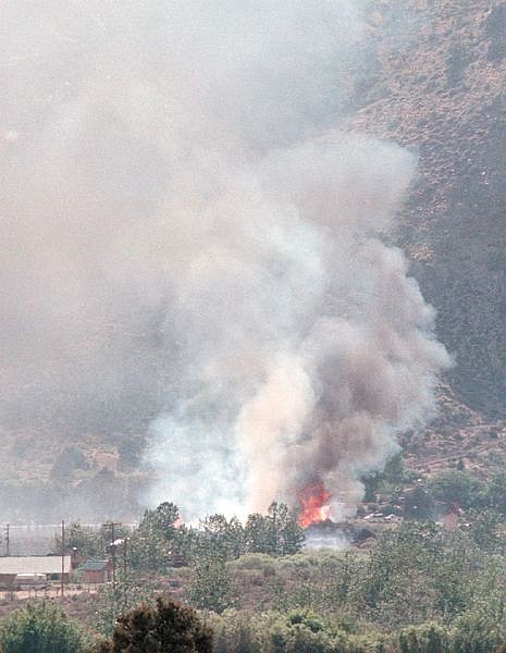 This is the view of the slurry plane on fire from the east side of the valley around Walker, Calif. Witnesses described a big explosion as it hit the ground just 150 feet from businesses in Walker. All three on board were killed in the crash. (AP Photo/The Record-Courier, Shannon Hall)