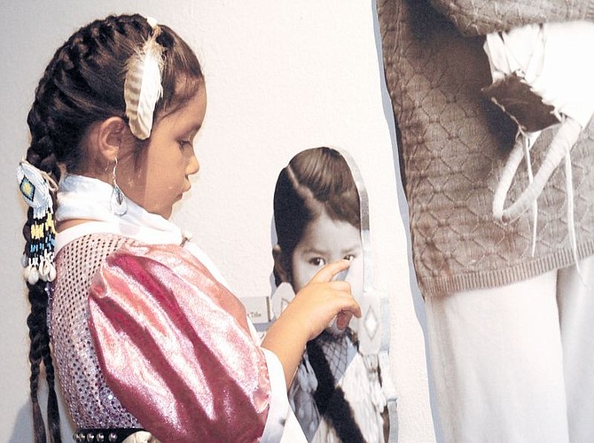 Shelby Autumn Smith, 5, a Cui-ui Dicutta Paiute, or Fisheaters Paiute, looks at part of the Under One Sky Exhibit at the Nevada State Museum which opened to the public Saturday. The exhibit shows a history of Native Americans in and around Northern Nevada, including the Paiute Indians. Photo by Brian Corley