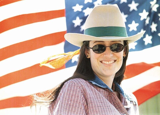 Kirstin Lambert smiles in front of the flag on her float in the Virginia City Parade. Photo by Rick Gunn