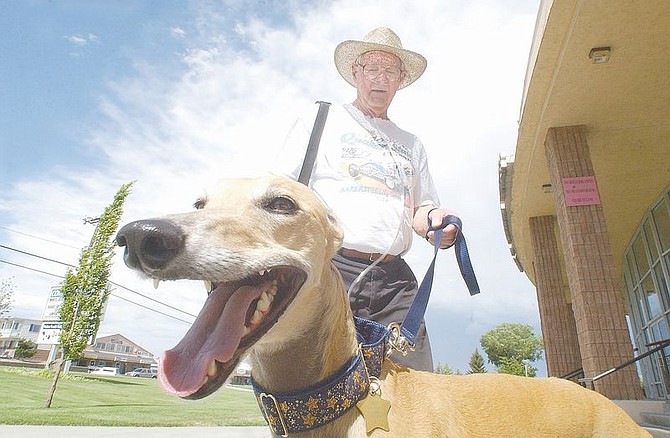 John Smith holds on to Janie, a 4-year-old Greyhound, at the Carson City Community Center after they finish their afternoon walk . &#124; Photo by Rick Gunn