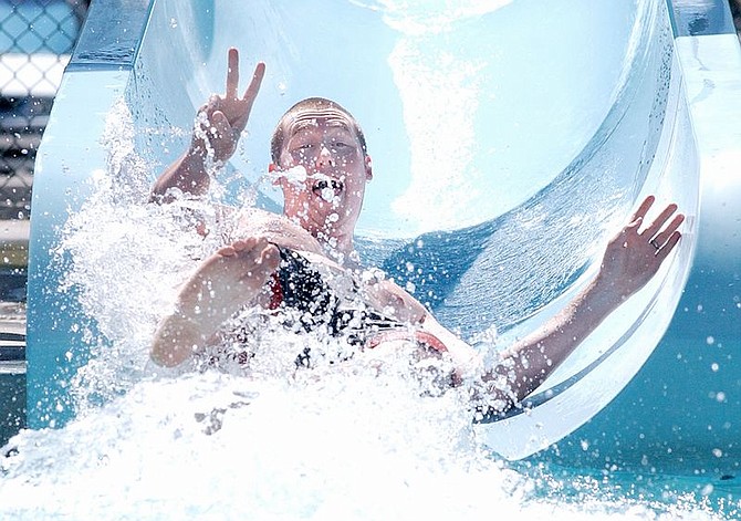 Andy Bucy of San Diego cools down on the water slide at the Carson Aquatic Center Tuesday afternoon.   photo by Rick Gunn
