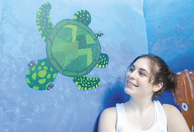 Artist Elizabeth Winslow looks at her sea turtle on the wall of the newly decorated Reading Room at the Nevada State Children&#039;s Museum.  The Reading Room was created with funds donated by the Soroptomists and replaces the Egyptian room.