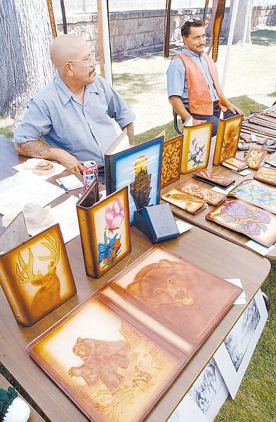 Nevada State Prison inmates Michael Doyle, left, and Hect or Castellon display some  of their leather artwork at a Prison Art Show Tuesday morning. The Art Show was open to the public and included art, poetry and refresments.