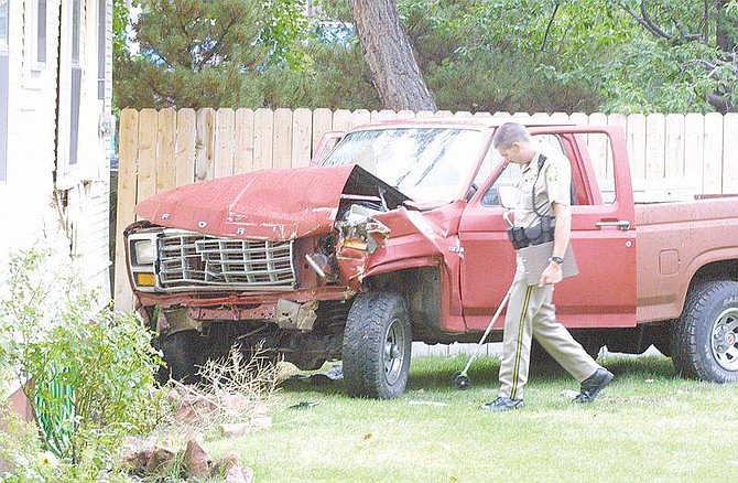 Photo by Cathleen AllisonCarson City Sheriff&#039;s Deputy Kevin Field conducts an investigation Wednesday afternoon after a man allegedly running from police slammed into a home during the pursuit. The suspect, Raymond Harold, was taken to Washoe Medical Center with head injuries.