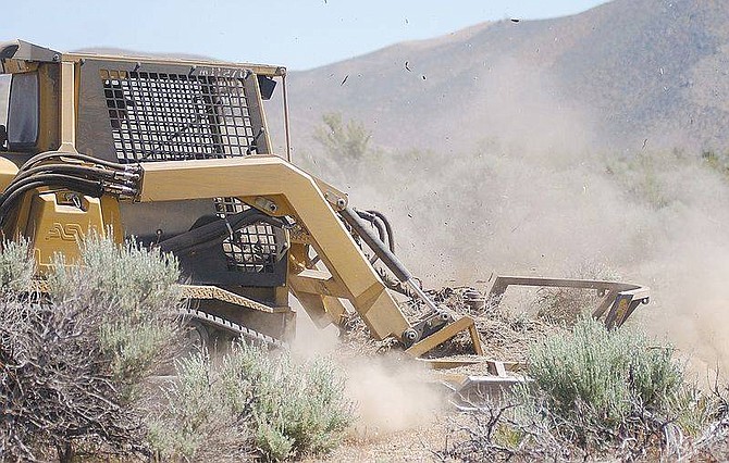 Photo by Bran CorleyTony Arce drives his bulldozer with front through some sage brush to turn the overgrown vegetation into mulch along the West side of homes along Kings Canyon Road. Little more than stumps were left after passing over the brush, clearing a fire break of more than 50 feet in minutes.