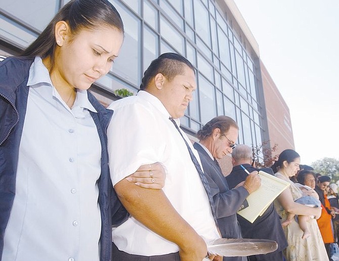 Kim Susunkewa, left, girlfriend of Rocky Boice, jr., holds the arm of Boice, jr. as he stands beside one of his attorneys, Laurence Lichter, as they join a prayer circle after the prelimanary hearing of the Resendiz Murder Trial. Boice is accused, along with nine others, of beating Sammy Resendiz to death in 1998 at the Round House Motel. Photo by Brian Corley