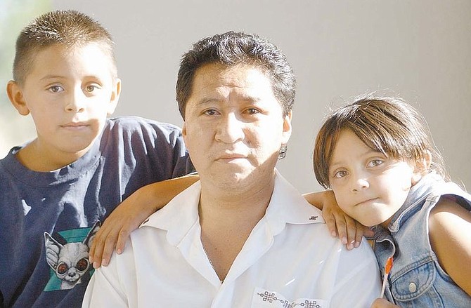 Jose Resendiz (center) is raising his niece and nephew after their father, Sammy Resendiz, was killed in 1998. The family is still waiting for the 10 men accused of the murder to go on trial. Left to right, Sammy Jr., 9, Jose, and Gabriela Resendiz, 7. &#124; Photo by Rick Gunn.